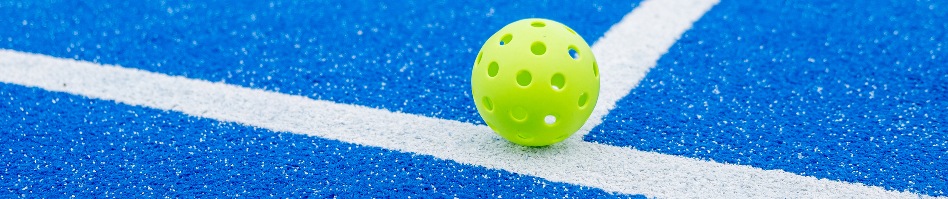 green pickleball ball in a pickleball court, new racket sport co